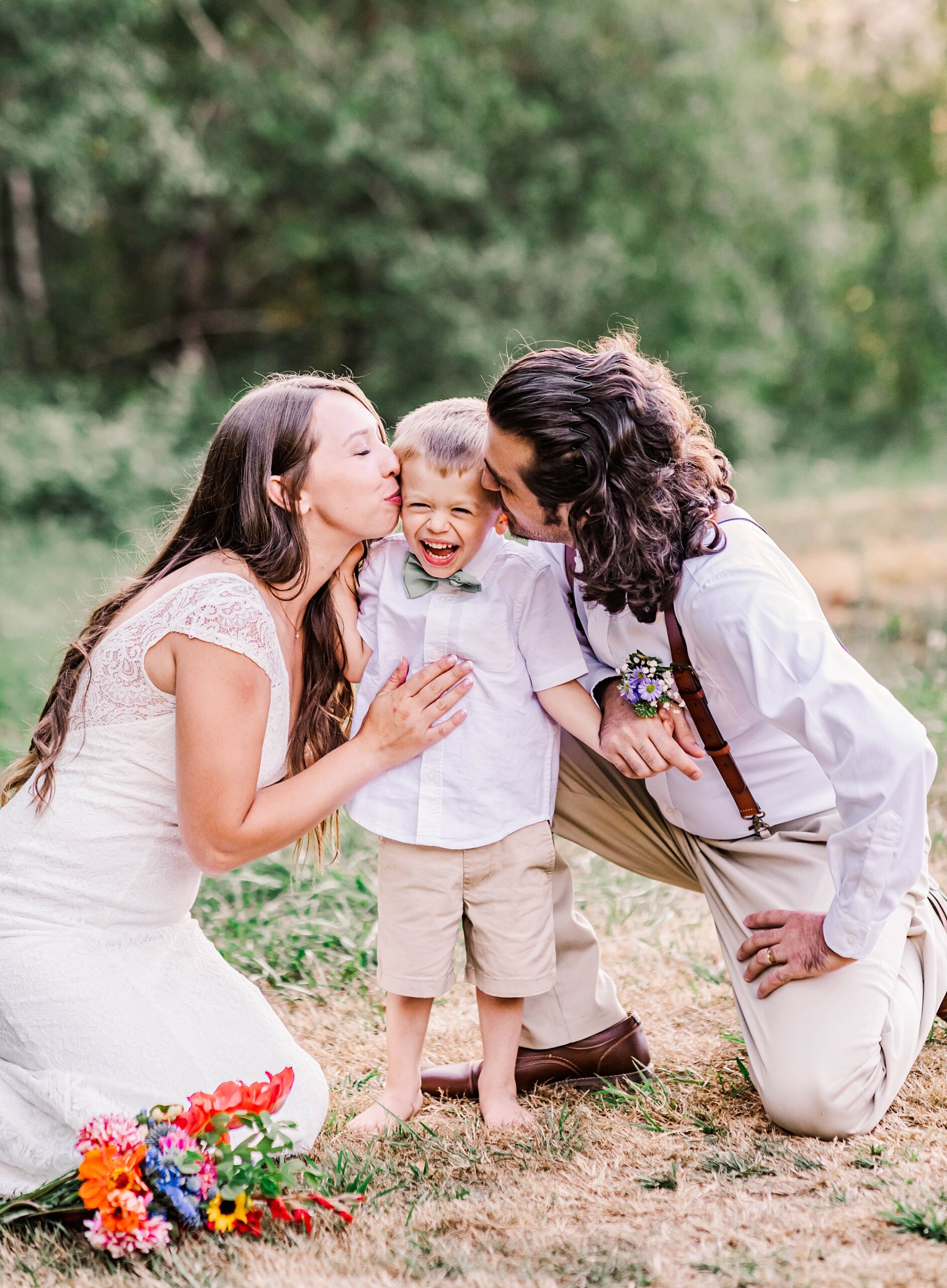 bride and groom kiss their son's cheek